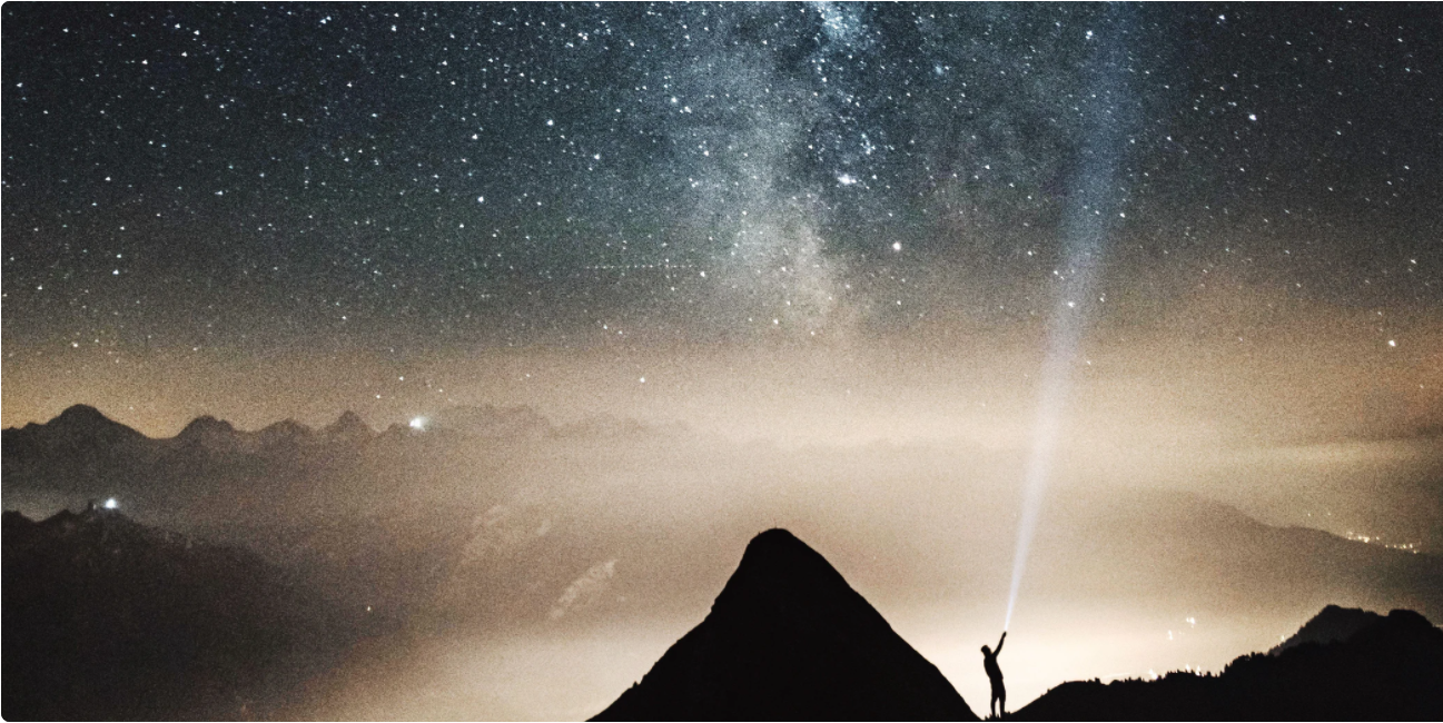 Image of Stars and Mountains with Person holding something up to the sky